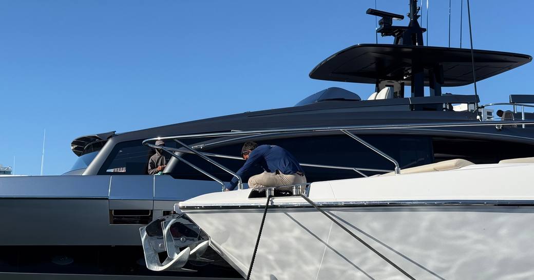 Crew member on bow of berthed motor yacht