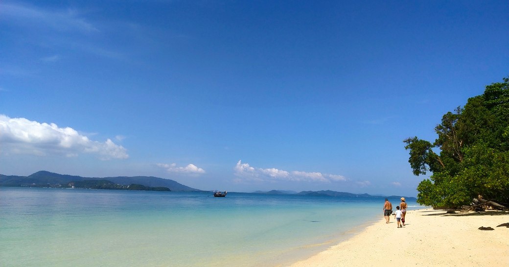 People on white sand beach along the Phi Phi islands