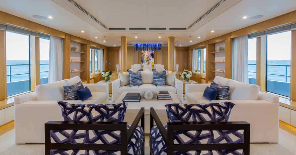 Light and airy open salon on Superyacht BACA with comfortable sofa and glass windows down either side