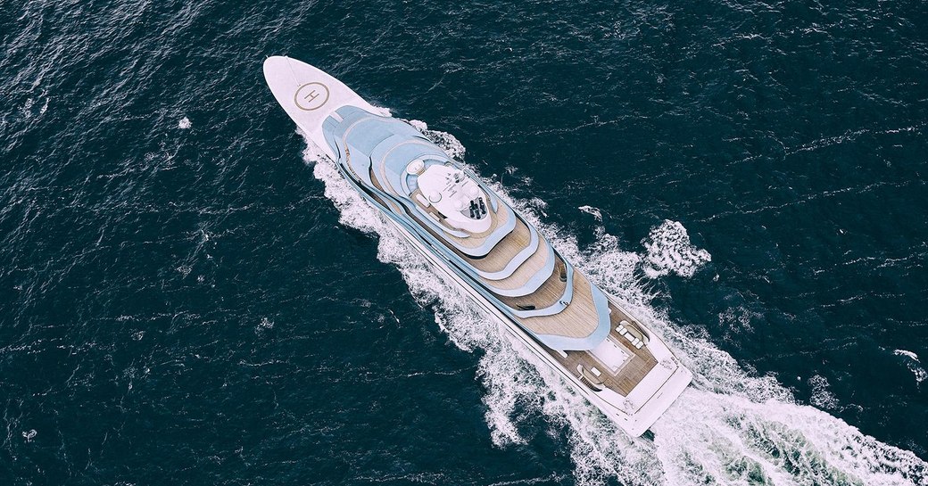 aerial shot of luxury yacht kaos, formerly known as jubilee, an oceanco yacht with blue superstructure and helipad on the foredeck