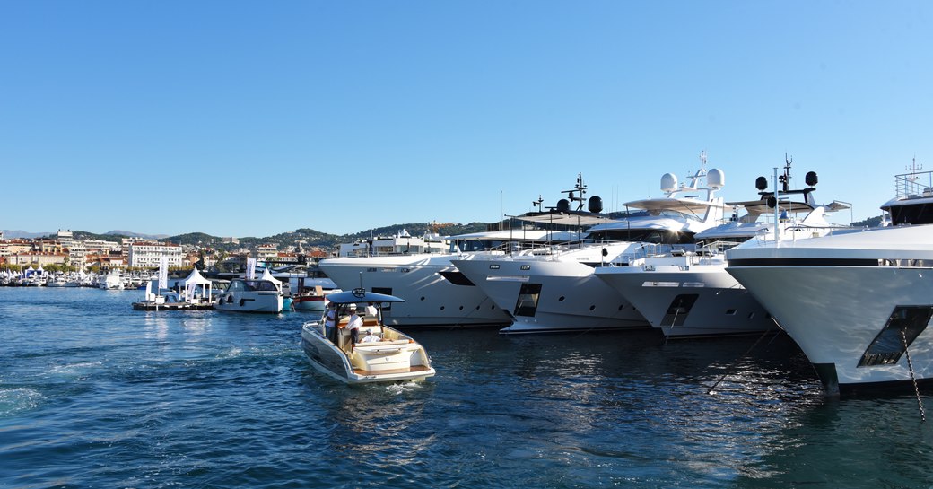 superyachts lined up at cannes yachting festival 2019, with tender cruising along in front of them