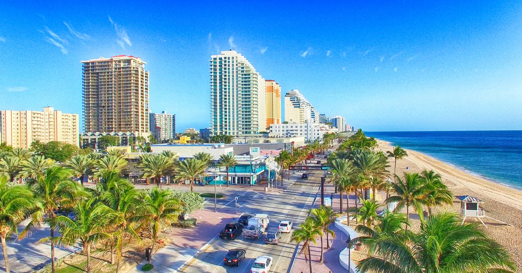 Overview of Fort Lauderdale coastline, towering hotels overlook busy road, sandy beach and sea to starboard.