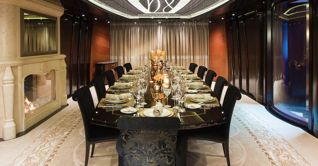 Formal dining area with long table and a fireplace onboard charter yacht WHISPER