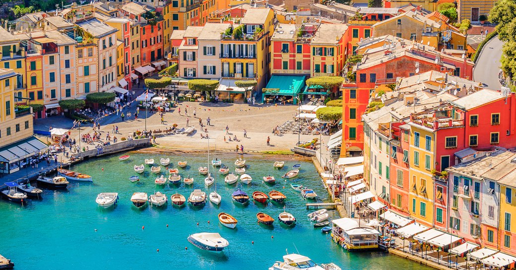 Aerial view looking down on the bay surrounding Portofino, with multiple boat charters at anchor