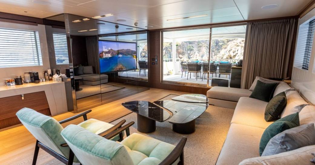 Interiors with lounge area and black coffee table onboard charter yacht ZEEMAR
