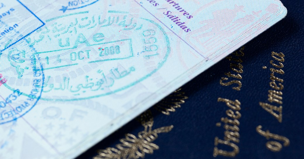 page of a passport with stamps on above an American passport