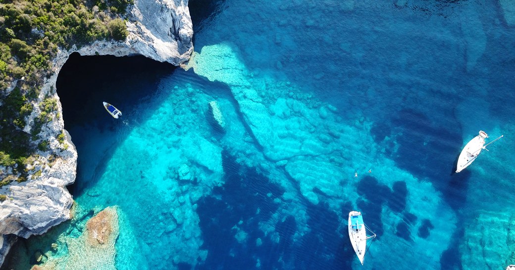 Secluded anchorage with yachts at anchor in the Virgin Islands, Caribbean with bright blue, clear sea