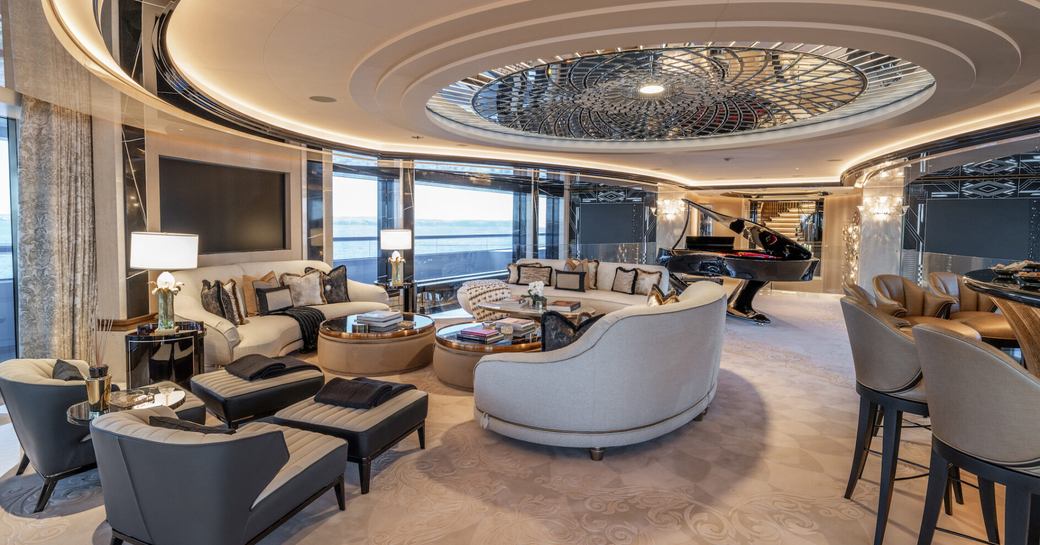 Interior lounge area with plush seating and a wet bar with stools onboard charter yacht KISMET
