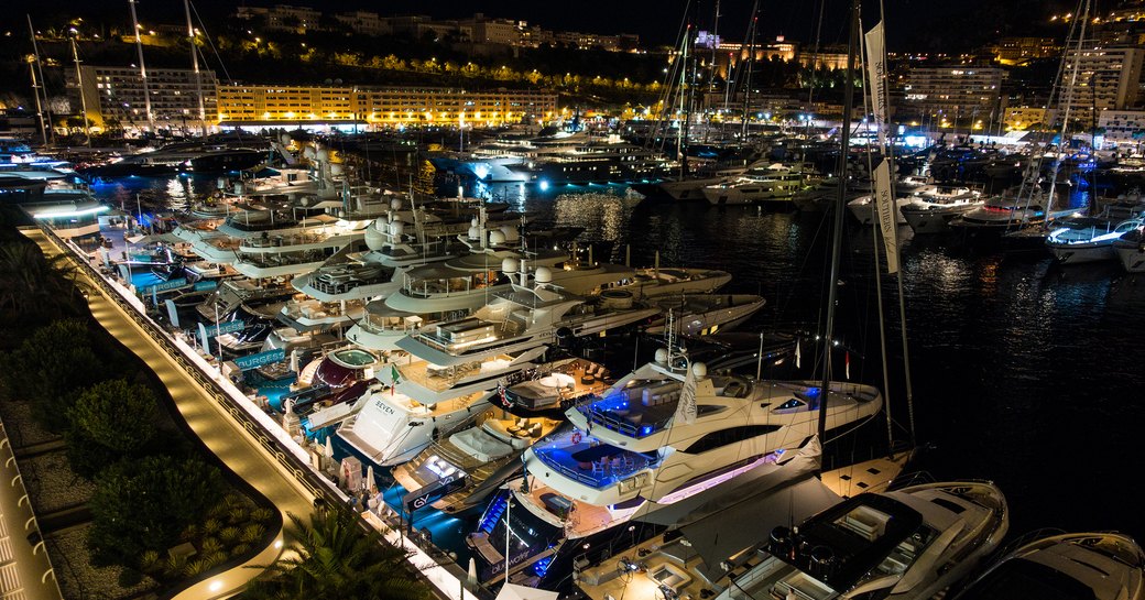 Yachts lined up at berth at night at Monaco Yacht Show 2018