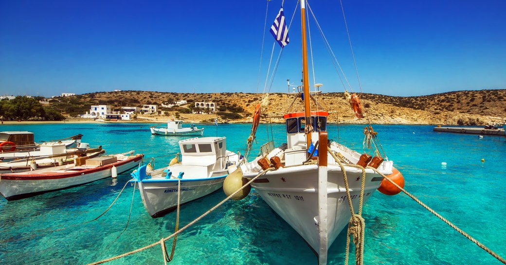 idyllic little harbour in greece, with boats bobbing on the water