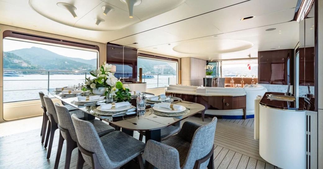 Main salon overview with dining area in foreground onboard charter yacht MIKOH