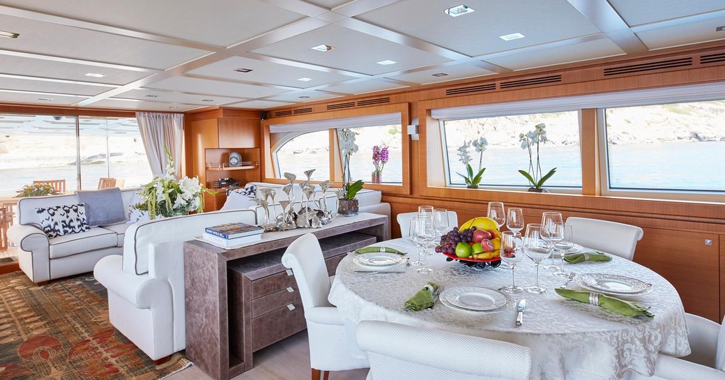 dining table and sofas in the main salon of charter yacht DEVA