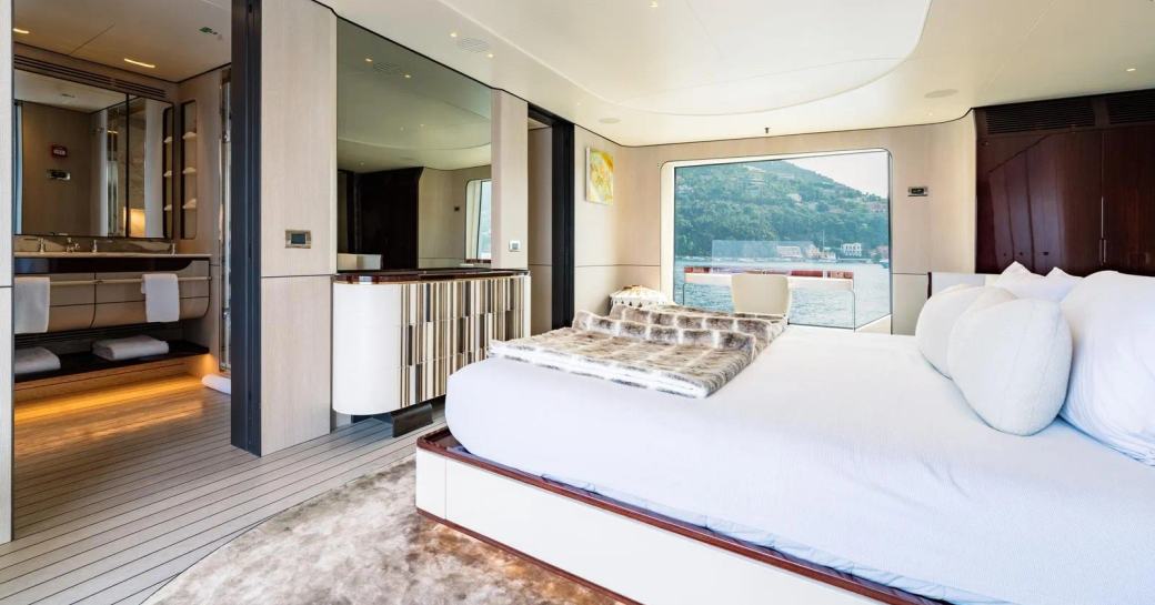 Overview of master cabin with central berth and large window onboard charter yacht MIKOH