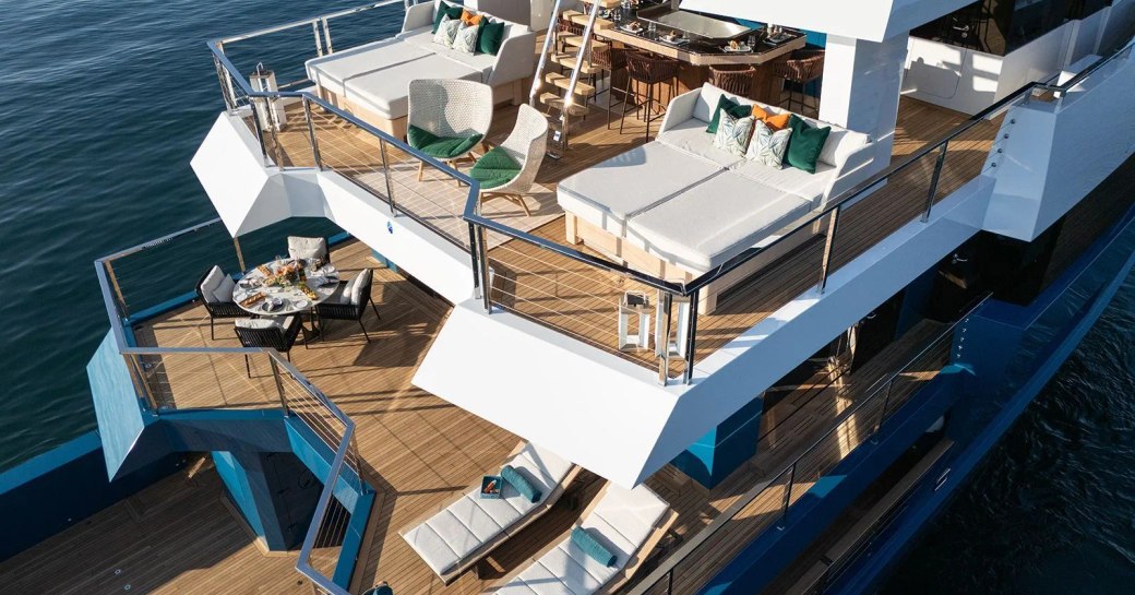 Overview of the aft decks onboard charter yacht KING BENJI, with sun loungers and alfresco dining options visible