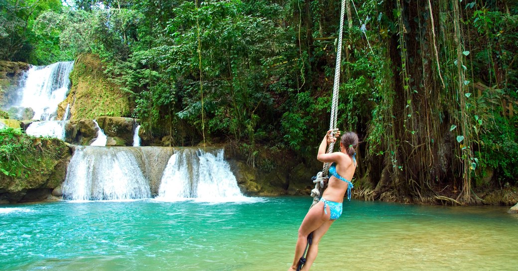 swinging into the waterfall pool in port antonia on our jamaica luxury yacht charter