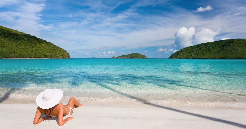 a charter guests relaxes on a beach during her charter vacation