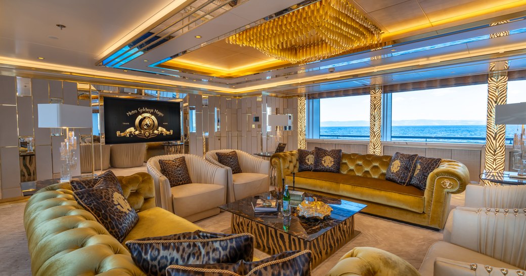 Interior lounge area onboard superyacht LEONA with a flatscreen TV and a wide-reaching window in the background.