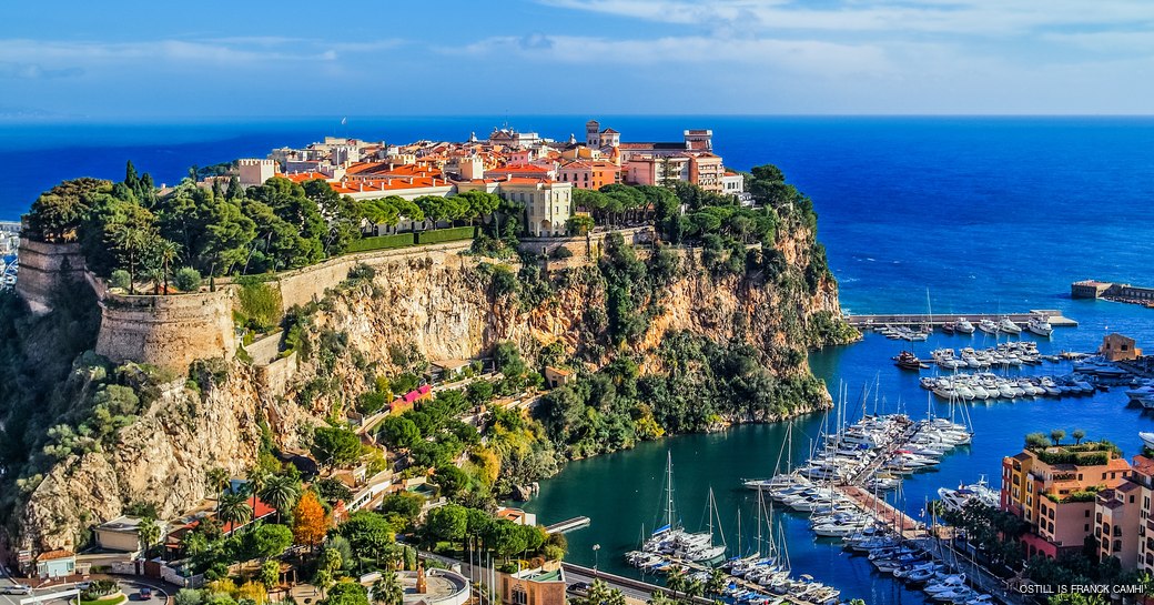 rocky hilltop overlooking yachts in a small harbour 