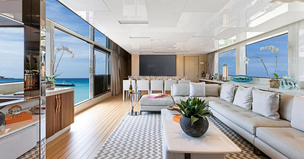 the bright and open salon on the main deck of superyacht freddy with large full length windows flooding natural water in to the luxuruious space