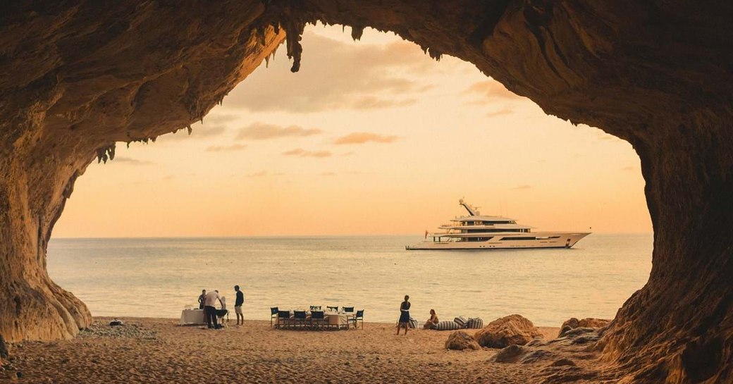 joy superyacht by feadship in water overlooking sardinian sandy beach of cala luna 