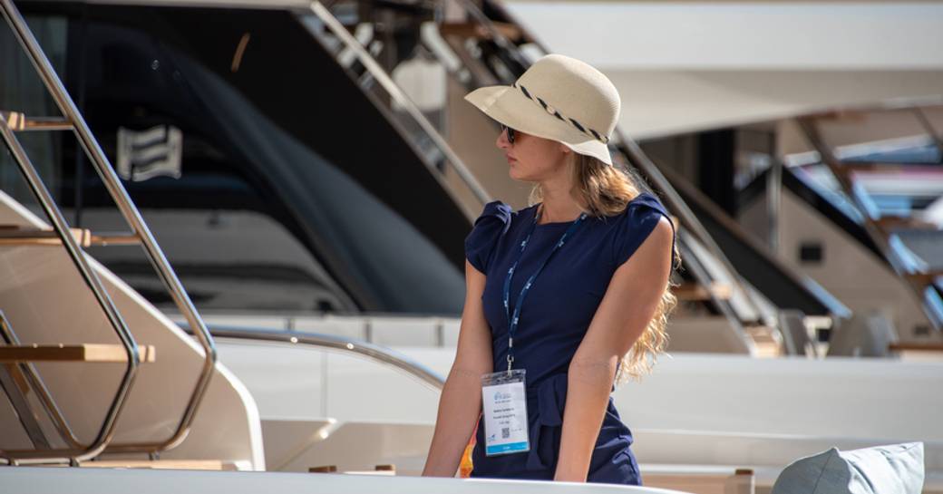 Landscape view of female charter guest onboard yacht at FLIBS, other yachts moored in background. 