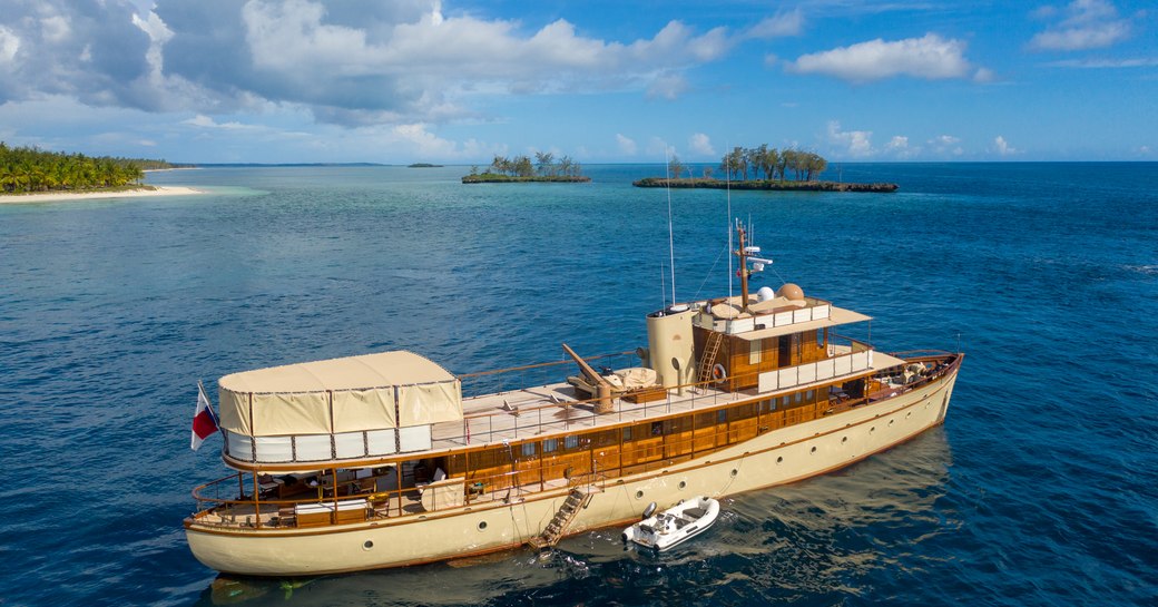 drone shot of superyacht over the rainbow on the sea in tanzania with islands in background