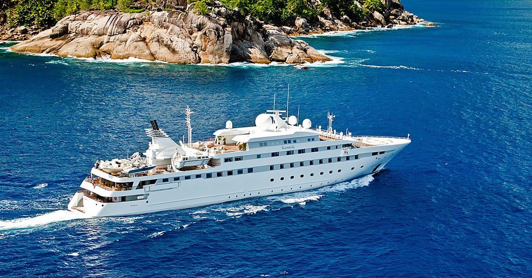 Superyacht 'Lauren L' cruising near to a green coast