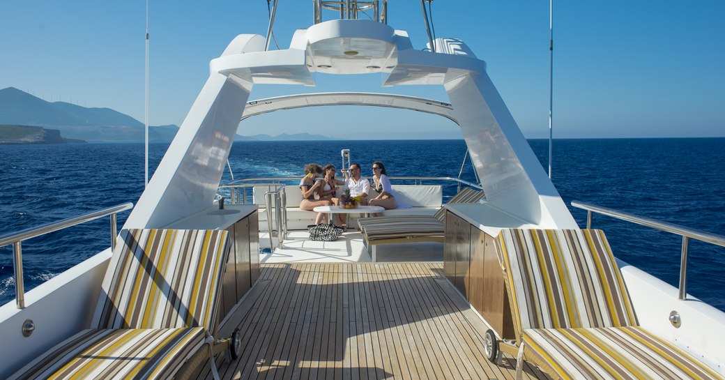 a group of friends enjoying the sun and panoramic view from the capacious and airy sun deck of charter yacht carmen fontana