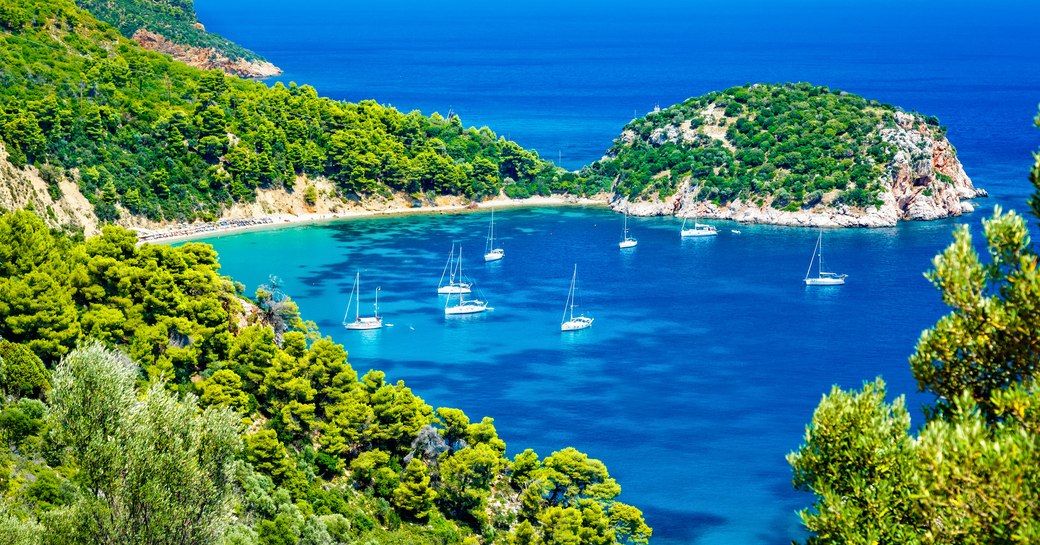 Yachts anchored in a sheltered cove in Greece