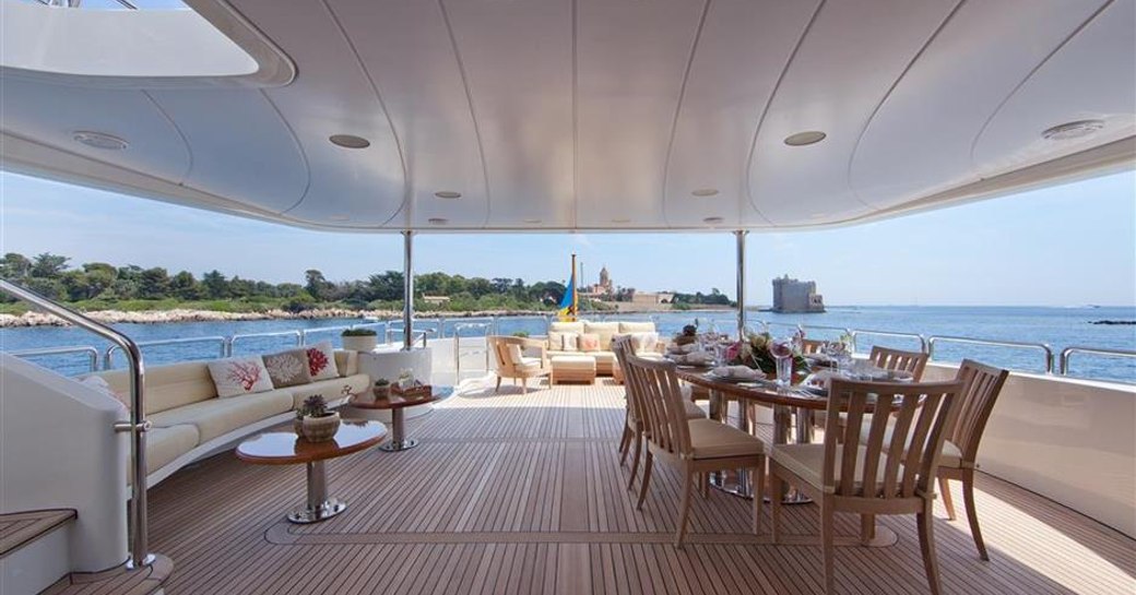 Upper deck of charter yacht BRUNELLO with formal alfresco dining and sofa seating