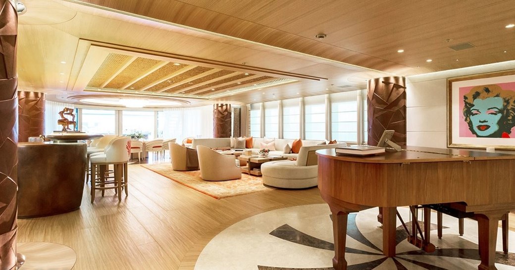 piano, bar and lounge area in main salon of luxury yacht ‘Here Comes The Sun’