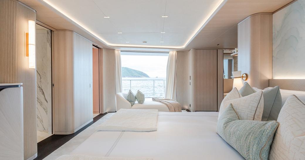 Charter yacht M master cabin with berth in the foreground and open balcony in the background