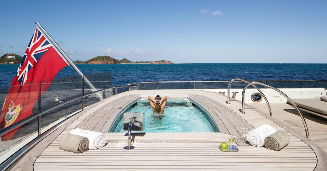 A guest relaxes in the Jacuzzi on board superyacht Grace E