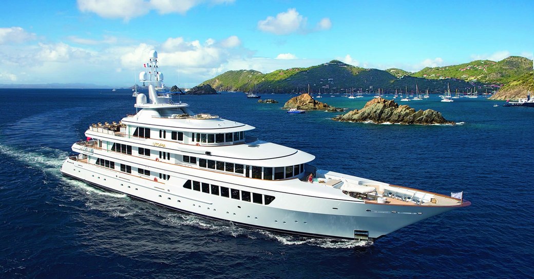 Profile shot of superyacht UTOPIA on the water with Caribbean islands in the background