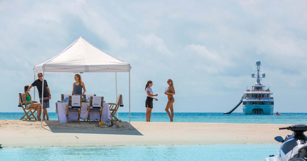 luxury yacht and beach picnic, with beach picnic on sand bar