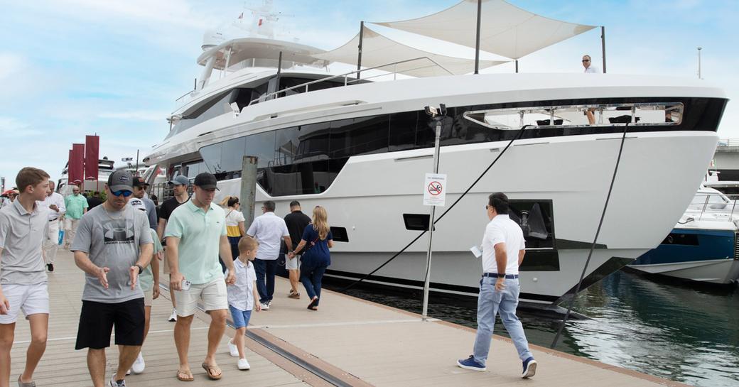 Motor yacht charter berthed at Miami International Boat Show with visitors walking by