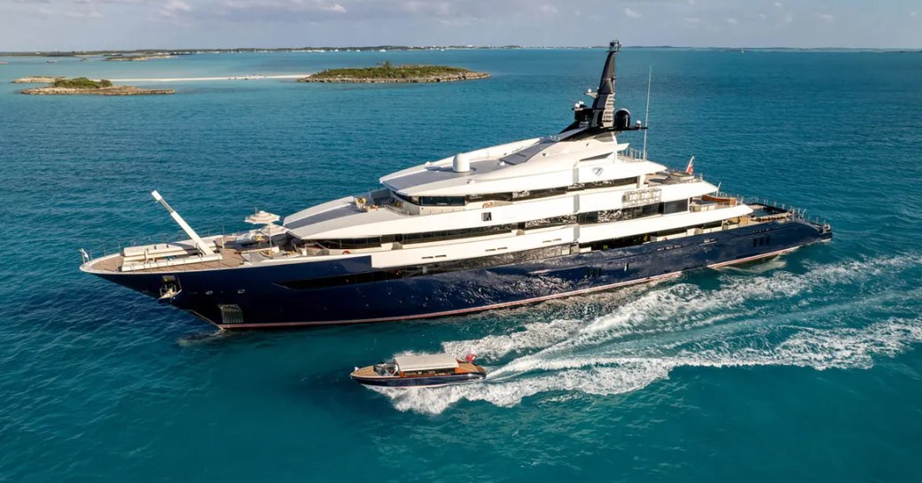 Charter yacht MAN OF STEEL at anchor with a tender underway alongside