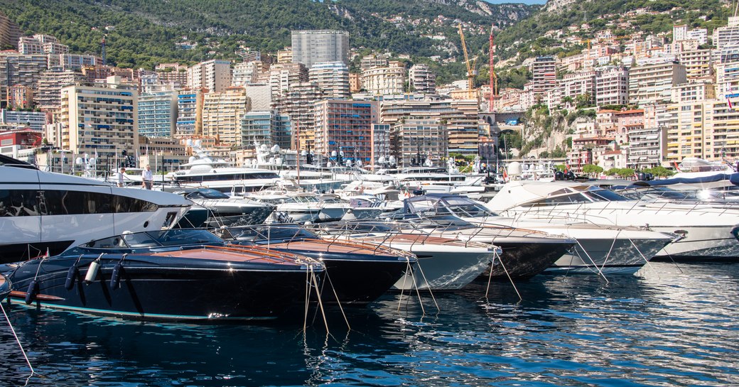 Overview of Port Hercule, Monaco, during the Monaco Yacht Show. Many superyachts lined up in front of Monte Carlo.