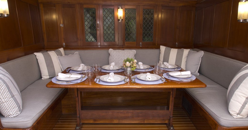 U-shaped seating and dining table in the interior of luxury yacht EROS