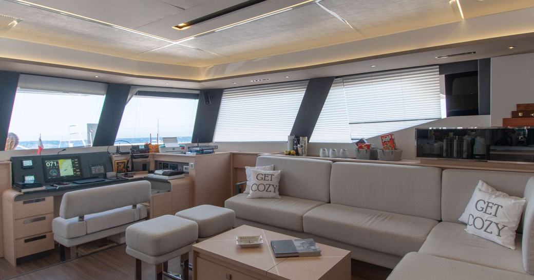 Overview of the main salon onboard charter yacht SERENISSIMA III, lounge area with wide windows behind