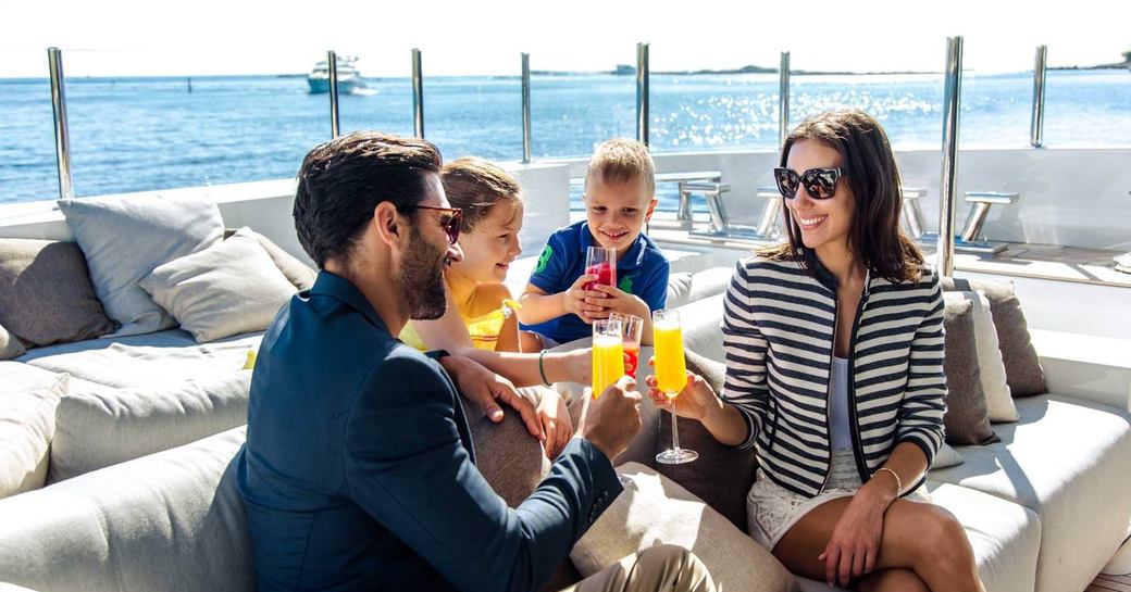 a family on a luxury yacht charter vacation enjoy some refreshments on their motor yacht after a safe journey to begin their charter in peace and tranquillity in the midst of a pandemic 