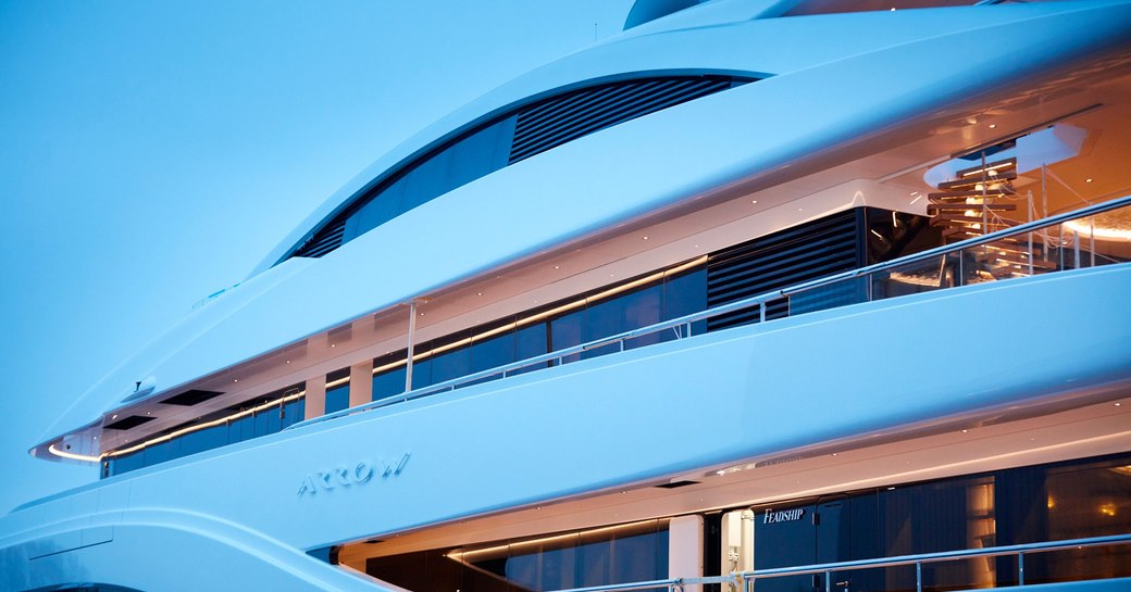 side profile of superyacht arrow as night falls, name plate on side of yacht visible