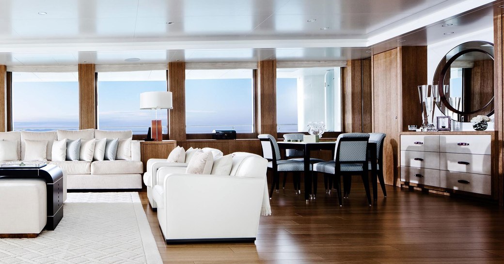 interiors of m/y lady e, with sleek black chairs and white sofas and hardwood flooring