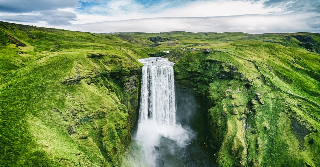 waterfalls and green rolling hills in Iceland