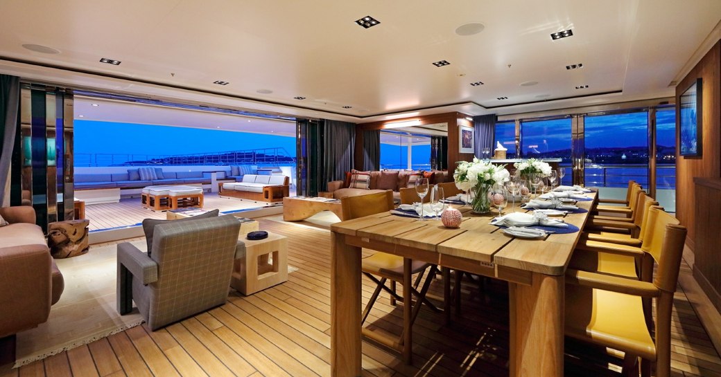 dining table and seating areas in the main salon aboard luxury yacht Planet Nine 