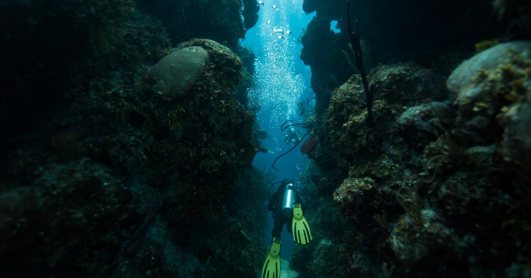 Scuba diver swims through blue hole