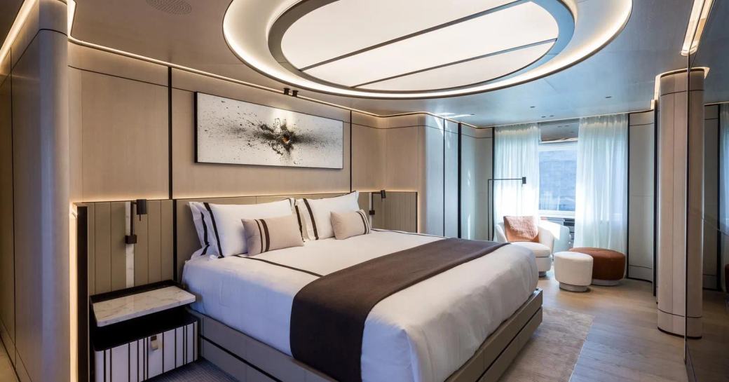 Master cabin onboard yacht charter AKULA, central berth with large window and seating area aft