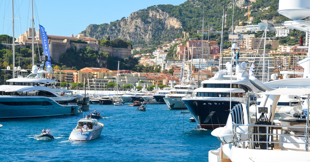 busy port hercules in monaco on a bright summers day, superyachts docked across the harbour