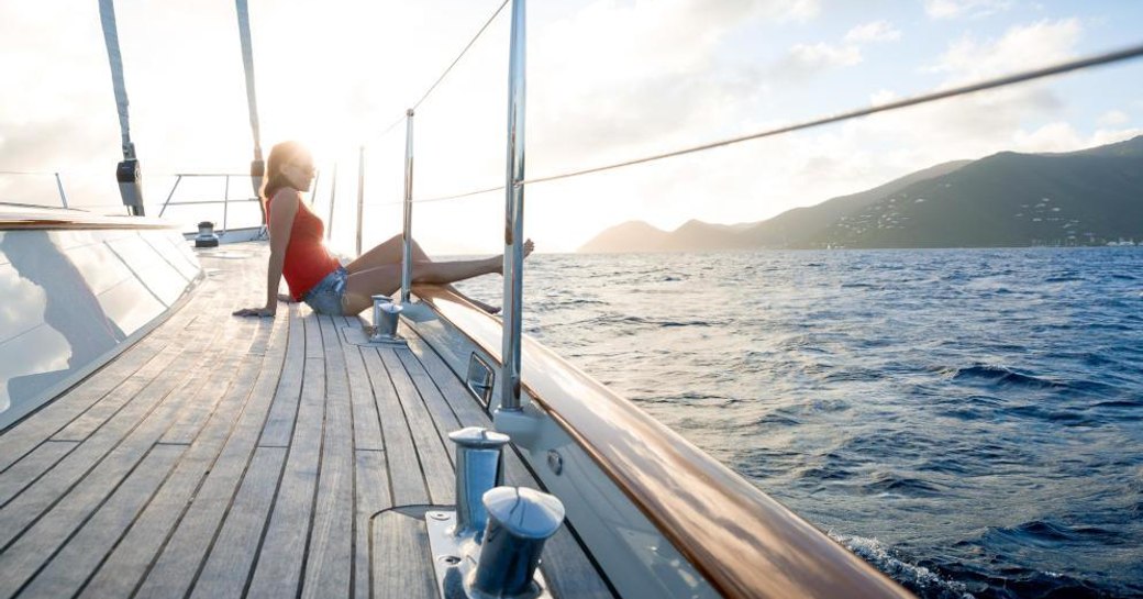 A charterer reclines on the sundeck of sailing yacht MARAE