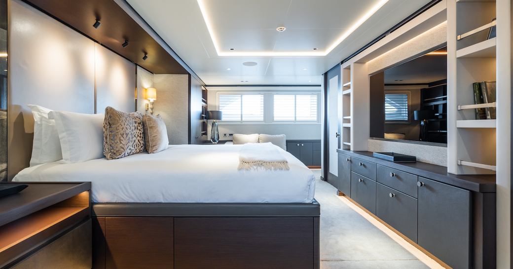 Overview of the master cabin onboard superyacht charter EMERALD with central berth and large window aft